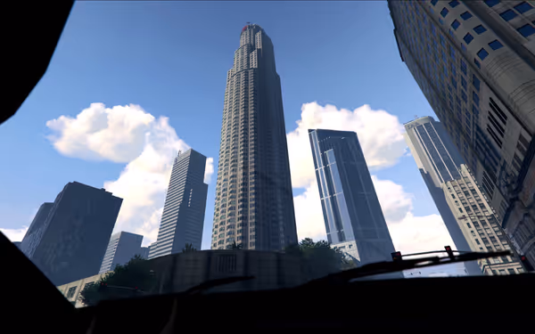 A tall skyscraper surrounded by other modern buildings under a bright blue sky.