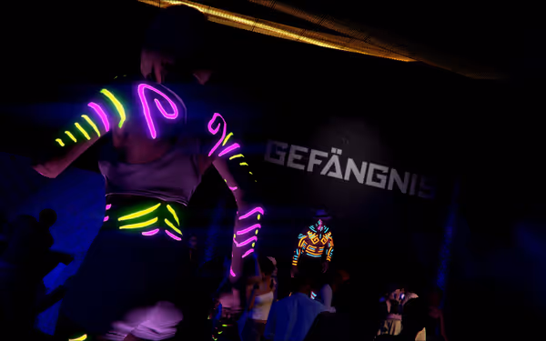 A nightclub with neon dancers, sign reading GEFANGNI, and people watching from below.