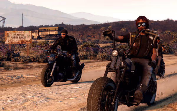 Two bikers ride past a "Los Santos Airbase Bunker" sign in a desert area.