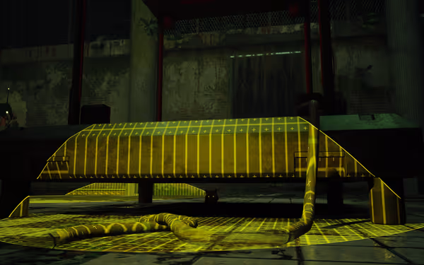 A black cat sits under a large machine with glowing yellow grid patterns on the floor